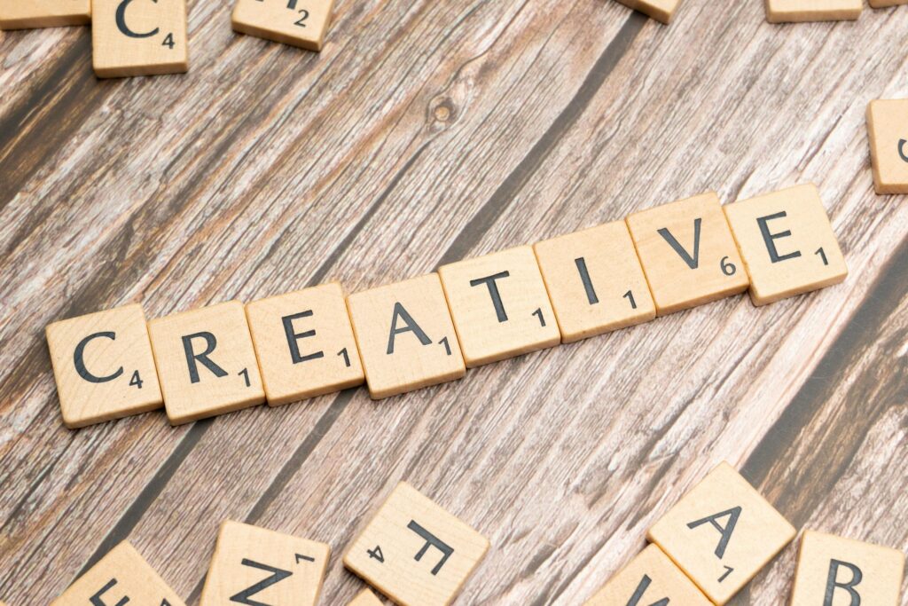 Wooden tiles on a rustic background spelling the word 'creative'.